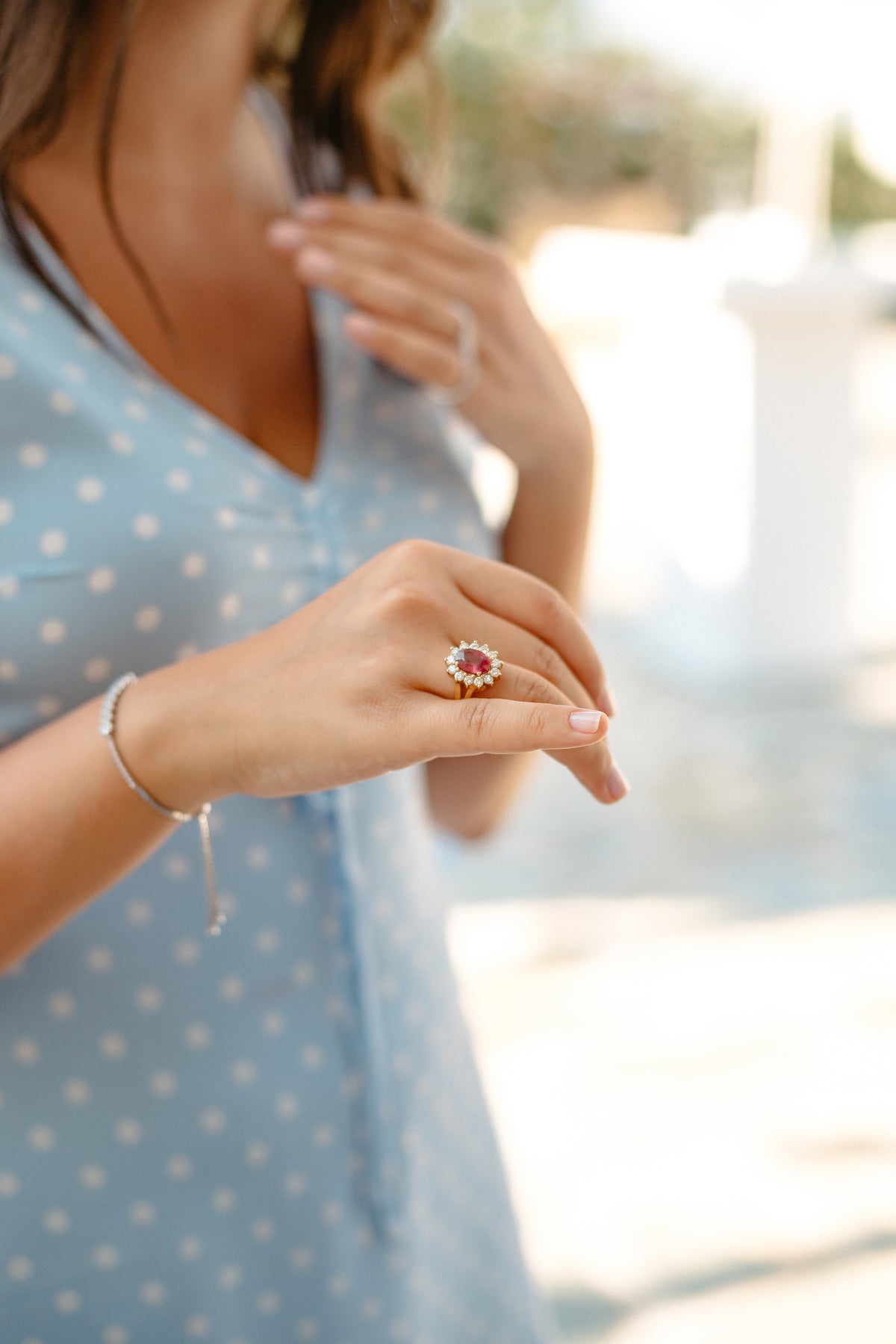 Person holds their hand forward displaying a diamond ring